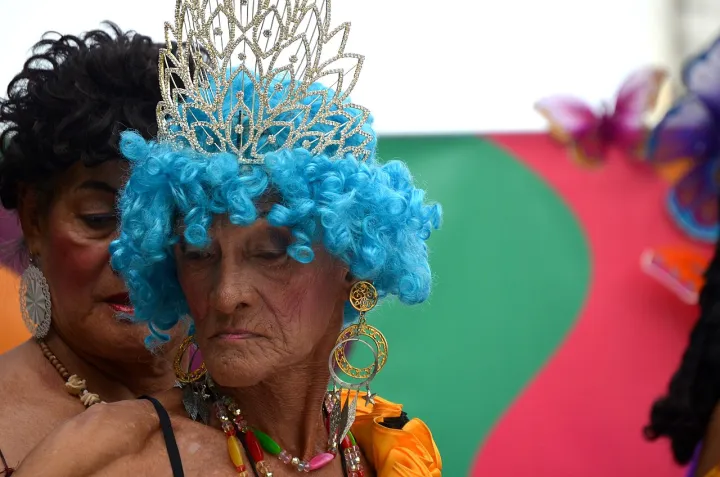 Pride participant gets help from colleague in fixing necklace