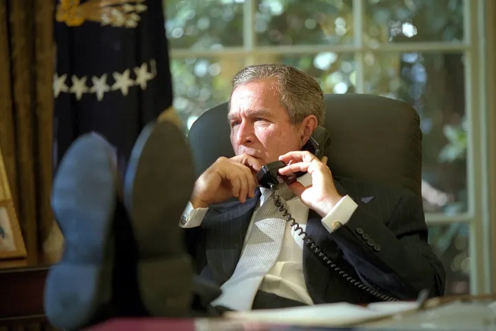 George W. Bush with his feet on desk