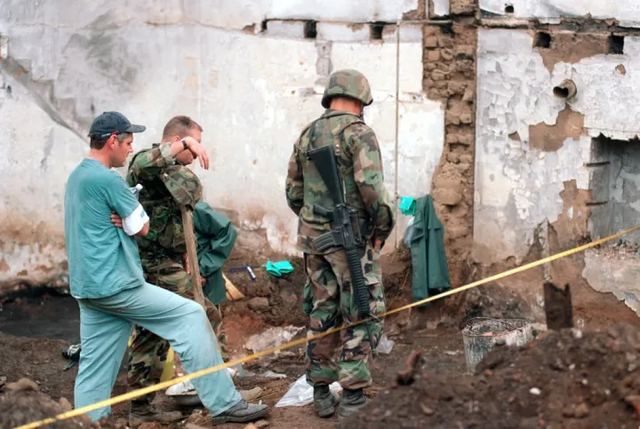 USMC provide security for RCMP investigators combing for war crimes evidence in Kosovo (July 1999)