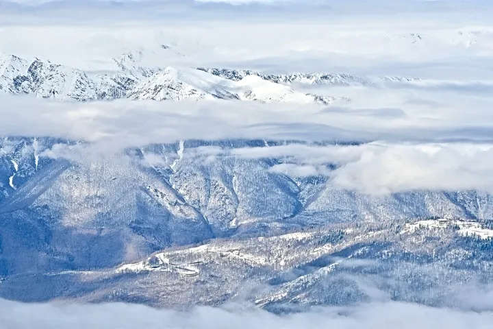 A view of the mountain peaks under the clouds in the vicinity of the resort village of Krasnaya Polyana from an altitude of 2320 meters above sea level