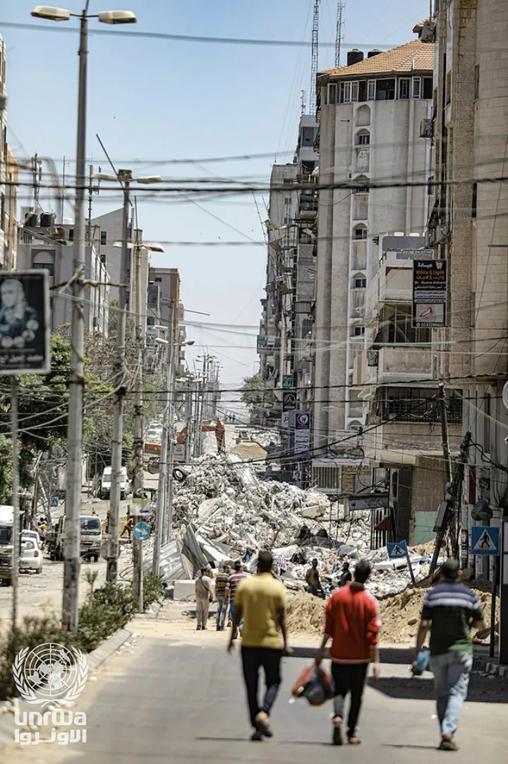 Palestinians inspect a damaged tower building which was hit after an Israeli air strike, amid a flare-up of Israeli-Palestinian violence in Gaza City