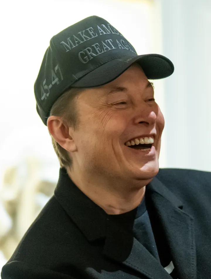 Elon Musk laughs while President Donald Trump holds the first cabinet meeting of his second term on February 26, 2025 at the White House (cropped)