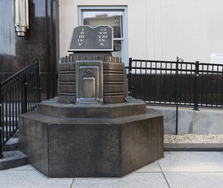 This still-standing granite block carrying a metal tablet symbolizing the biblical Ten Commandments, and an identical mate on the other side of the entryway, we