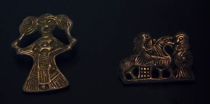 Silver figure with hair and silver figure with horse