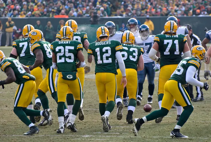 Quarterback Aaron Rodgers (12) and the Packers break the huddle.